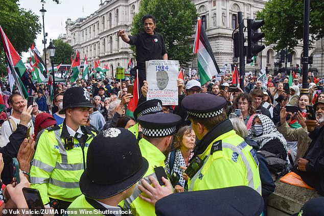 Pictured: A protester held up a '1984' sign criticising the Met Police at a protest in Whitehall on July 19