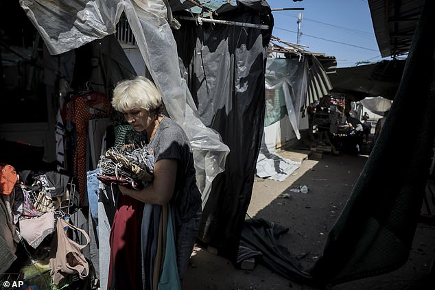 A seller leaves the market hit by Russia's drone attack in the town of Druzhkivka, Donetsk region, Ukraine, Saturday, Aug. 2, 2025