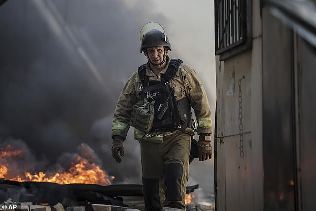 A firefighter puts out the fire after a Russian drone hit the market in the town of Druzhkivka, Donetsk region, Ukraine, Saturday, Aug. 2, 2025
