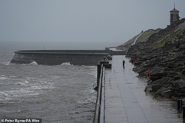 Waves seen crashing against the sea wall as the storm hits Blackpool in Lancashire this morning