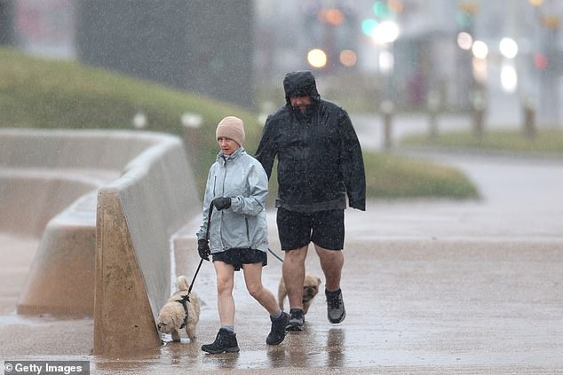 A couple braves the weather on Blackpool Promenade this morning as Storm Floris begins to hit parts of the UK