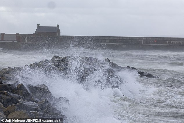 Waves crash over the rocks on the seafront at Saltcoats as Storm Floris hits the UK