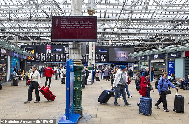 Commuters walk around the train station in Edinburgh with suitcases as disruption is expected