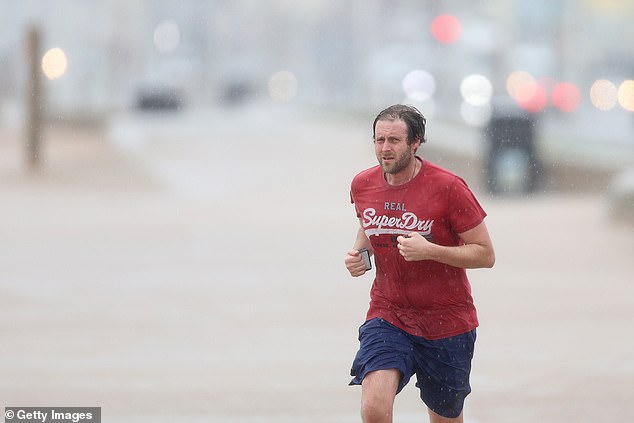 A man braves the weather as he runs down the Blackpool Promenade in the wind and rain