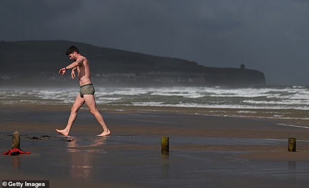 A swimmer battles against the strong winds on Portsteward Strand, Northern Ireland