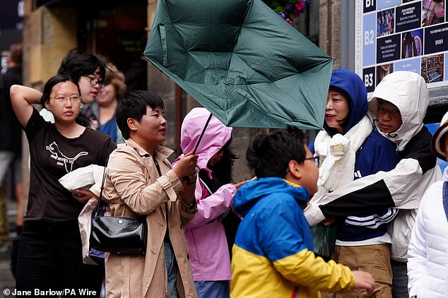 Members of the public battle against the wind and their own umbreallas as they walk along the Royal Mile, Edinburgh