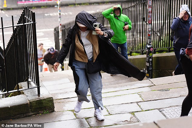 Members of the public battle against the wind as they walk along the Royal Mile, Edinburgh