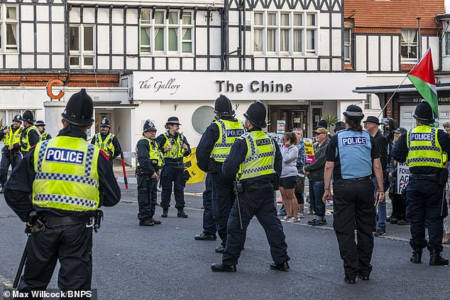 Police try to control protesters gathered outside The Chine Hotel in Dorset
