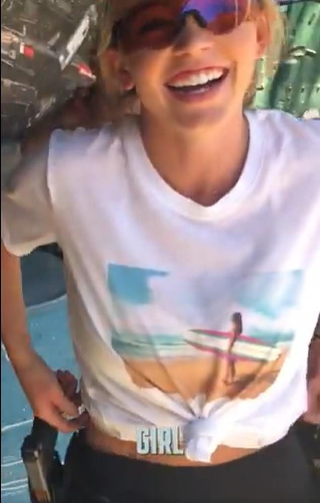 She wore a surfer shirt that was knotted in front with black leggings and glasses