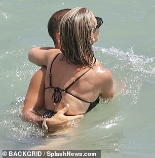 They looked in high spirits as Spencer picked up Vogue in the sea