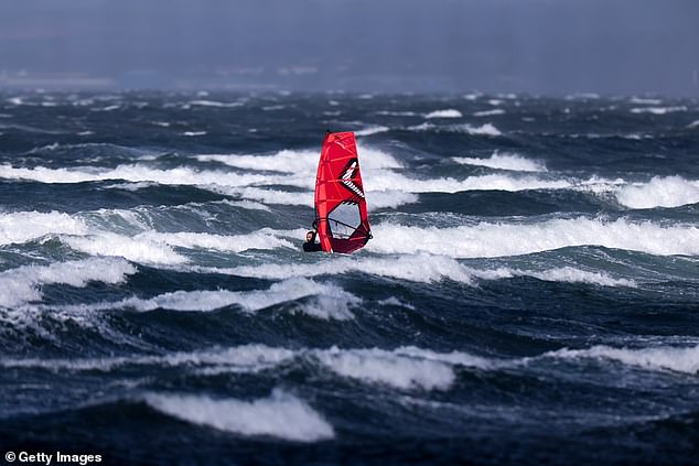 A windsurfer braces the elements in the stormy conditions off the coast of Troon in Scotland