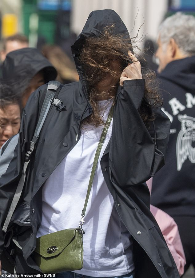 A woman struggles with wind blowing into her face as Storm Floris hits Edinburgh