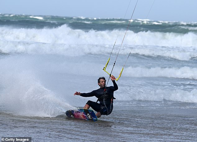 A windsurfer takes advantage of the speedy gusts in Portstewart, Northern Ireland as Storm Floris batters the UK
