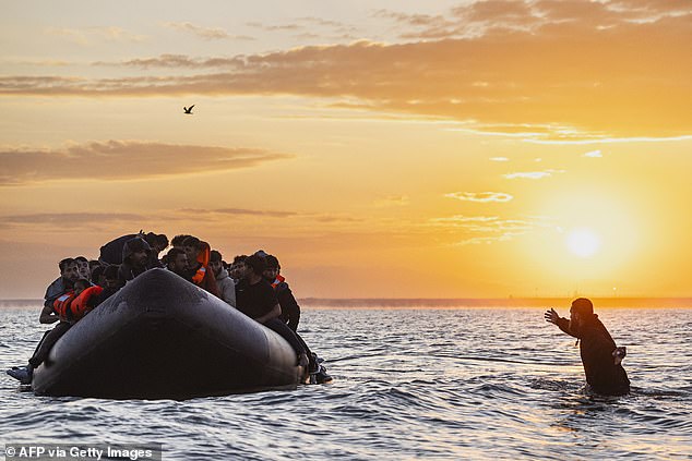 A migrant attempts to board a small boat off the coast of Gravelines, between Calais and Dunkirk, last week
