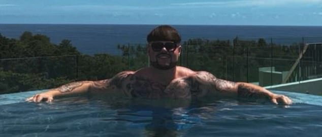 The muscular champ is covered in tattoos and sports bright white teeth as he dons the iconic bob