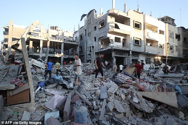 Residents in Gaza inspect the damage of an Israeli strike. A political analyst with Channel 12 quoted an unnamed official saying: 'Hamas won¿t release more hostages without total surrender, and we won¿t surrender