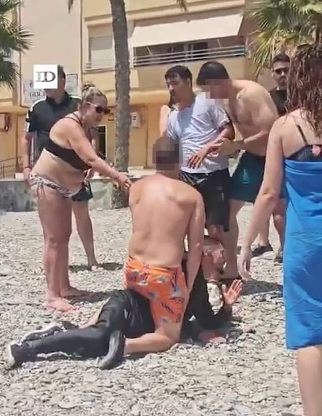 Witnesses branded the scenes as 'surreal'. In this photograph, a tourist is seen detaining one of the migrants
