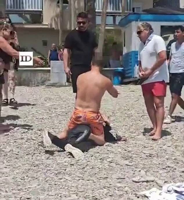 Dozens of boat migrants were tackled and detained by tourists after landing on a packed Spanish beach