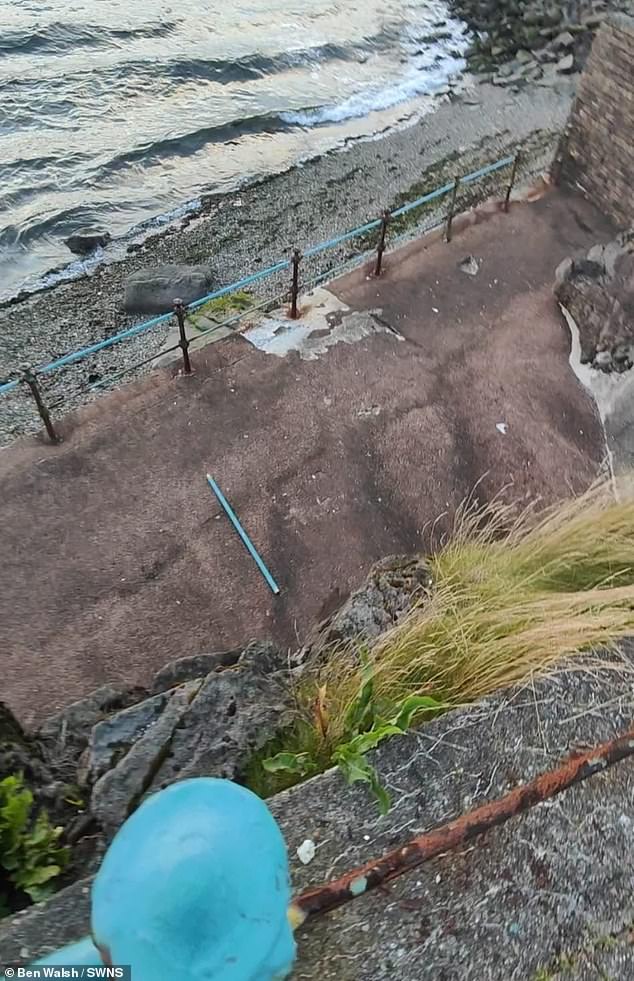 As the picture was being taken the railing the couple were leaning against gave way- leaving Ben dangling head-first above a 15-foot drop