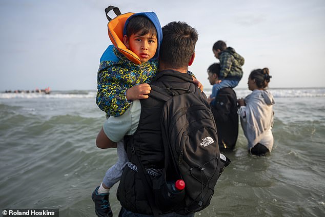One man was seen carrying carrying a child as he waded into the waters