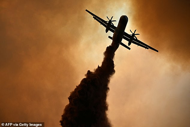 This photograph shows a canadair of the French civil security droping fire retardant over a wildfire near Fontjoncouse, southwestern France, on August 6