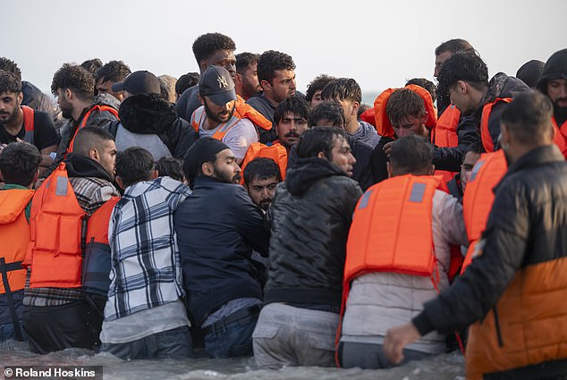 Migrants board a small boat near the beach in Gravelines, northern France