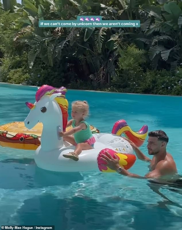 The influencer posted a video of boxer Tommy as he pushed Bambi along on an inflatable unicorn in the pool