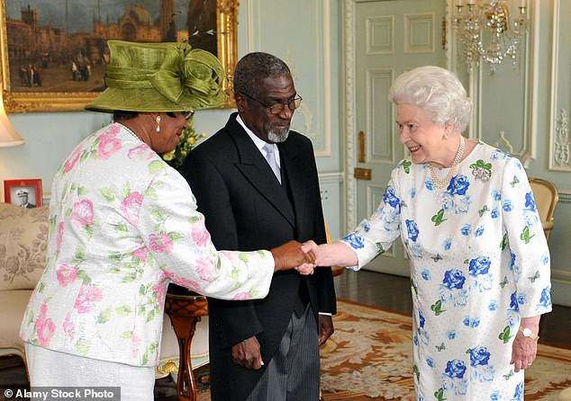 Queen Elizabeth II meets Sir Carlyle Glean, Governor-General of Grenada and his wife Lady Glean after receiving his knighthood from the monarch at Buckingham Palace in July 2009