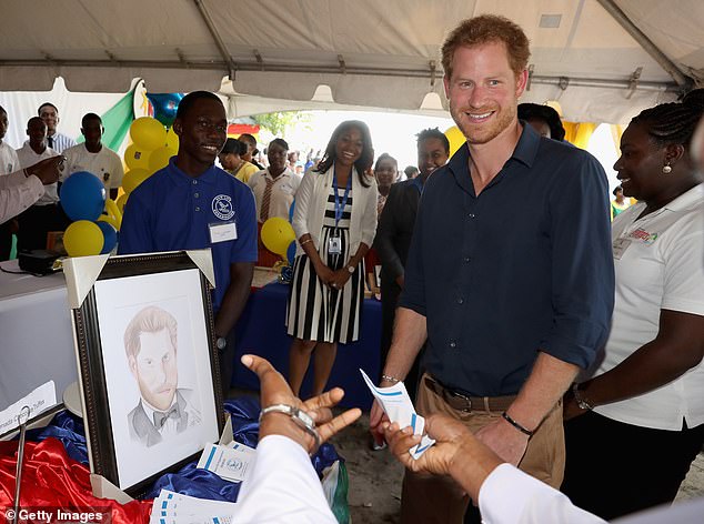 Prince Harry is presented with a portrait during a visit to Grenada in November 2016