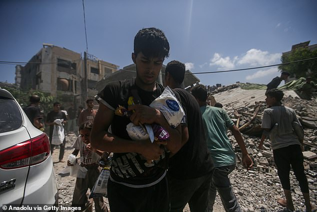 Palestinians flock to the area where aircrafts airdrop humanitarian aid attached to parachutes in north of Gaza City, Gaza on August 7