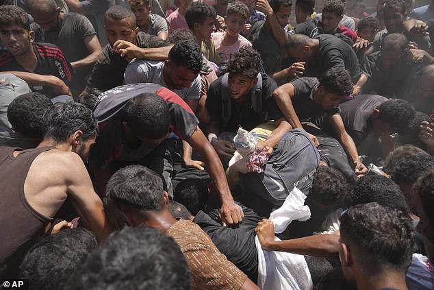 Palestinians struggle to collect humanitarian aid airdropped by parachutes into Gaza City, northern Gaza Strip, Thursday, August 7