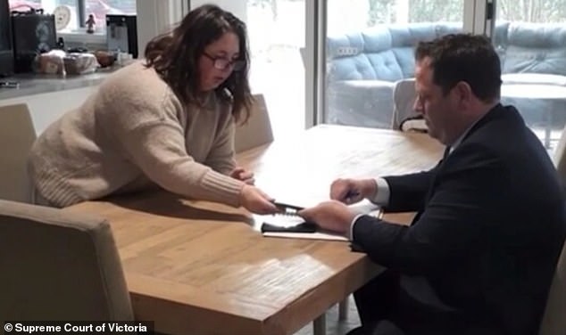 Erin Patterson hands over a phone to Homicide Squad Detective Sergeant Luke Farrell on August 5, 2023