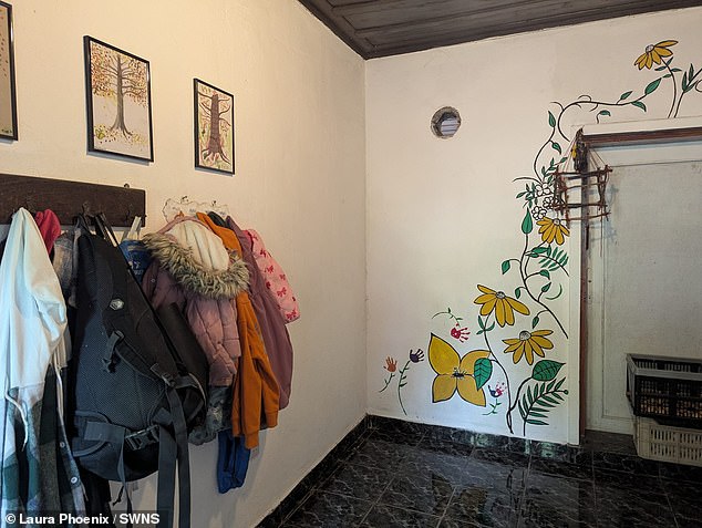 The hallway in their home - with a flowery mural painted up the wall as part of the renovation