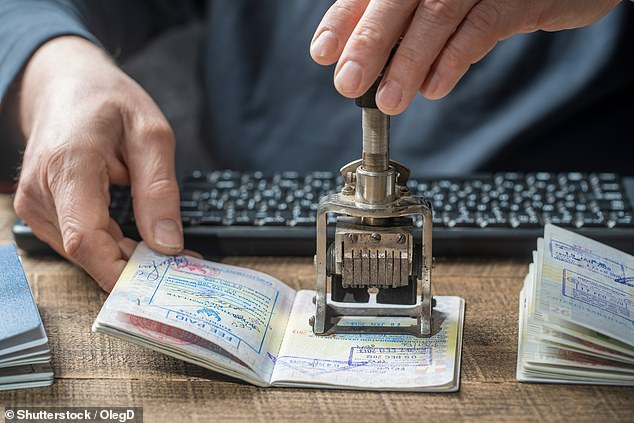 EES will replace the current manual stamping of passports for visitors to Europe's borderless Schengen area who are not nationals of EU or Schengen countries. Pictured: Border control officer puts a stamp in the international passport