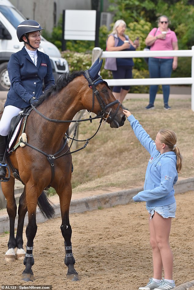 Mia Tindall is pictured petting her mother Zara's horse Showtime, while attending the Horse Trials at Hartpury in Gloucestershire on Saturday