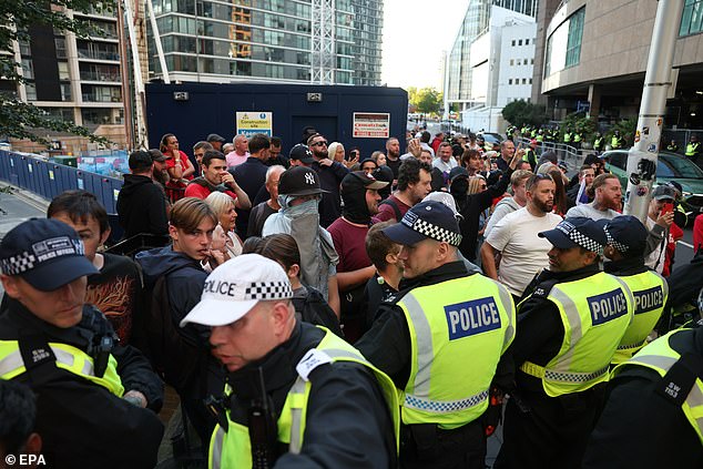 Mr Jenrick says foreign aid must be immediately cut to any countries that refuse deportations of their nationals who commit crimes on British soil – ‘even if they’ve qualified for settlement’ in Britain. Pictured: police officers outside of a migrant hotel in London on August 8