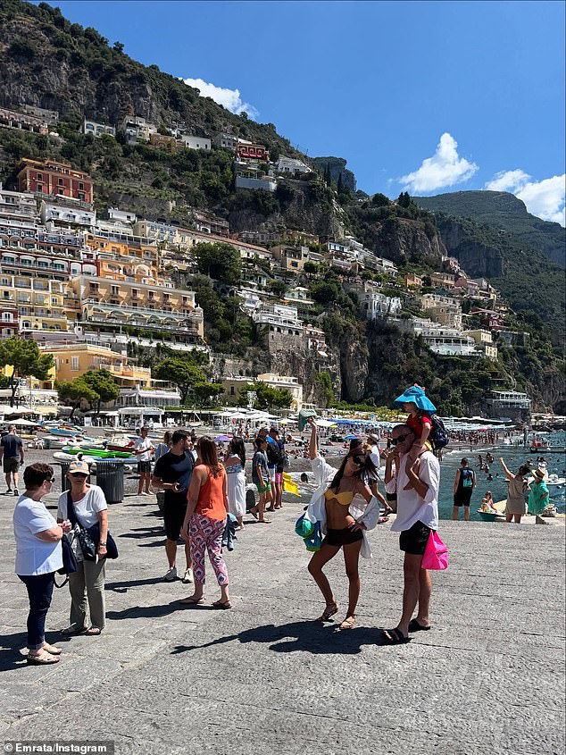In other daytime snaps, she was seen posing in a bright yellow bikini top and micro shorts as she and a pal, who appeared to be carrying her son on his shoulders as they stood in the middle of a crowd of tourists, posed for the camera