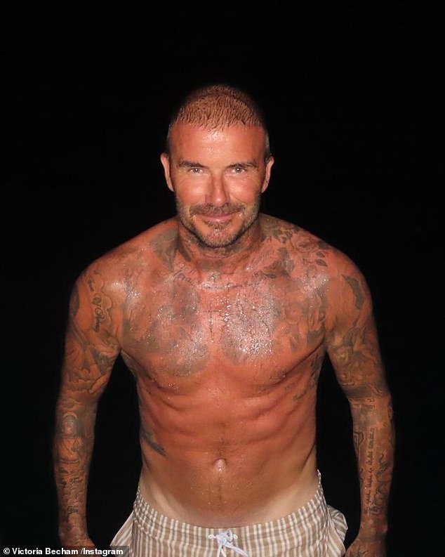 Victoria snapped David as he emerged from a late-night dip in the sea, showing off his ripped physique and impressive tattoos