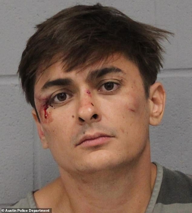 Accused gunman Ethan Blaine Nieneker, 32, in his booking photo at the Travis County Jail, showing him staring straight at the camera with several fresh cuts on his face
