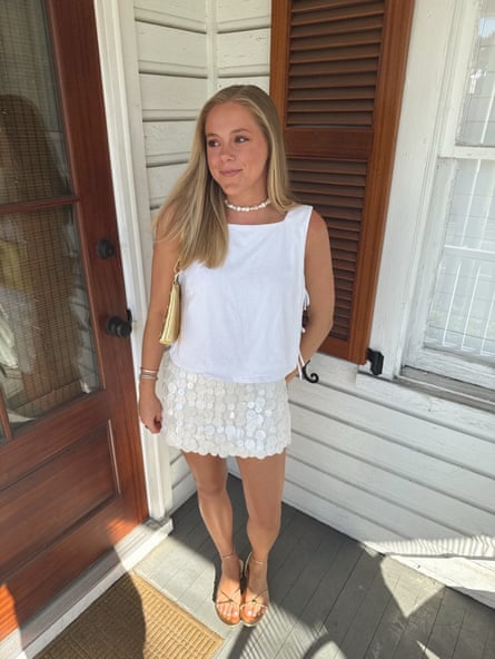 A woman poses in a flashy outfit outside a house