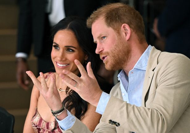 Britain's Prince Harry (R), Duke of Sussex, speaks with his wife Meghan Markle 
