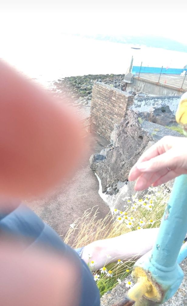 Ben Walsh hanging from the cliff