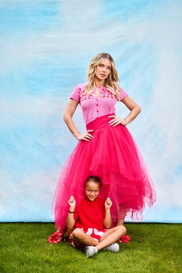 Helen flanagan in pink in garden with daughter at her feet