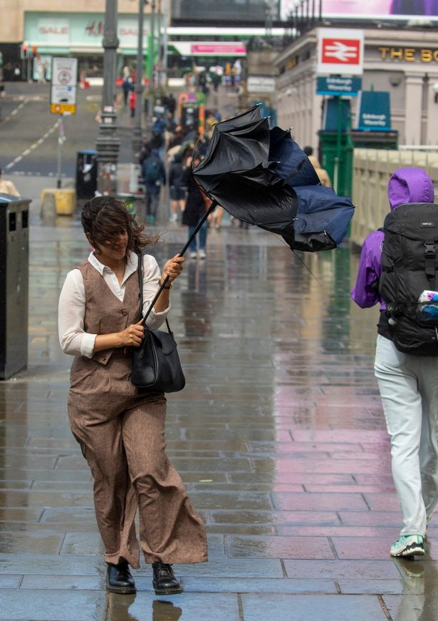 A woman battles with an umbrella as Storm Floris hits Edinburgh