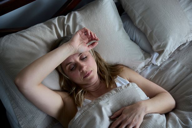 Woman sweating in bed