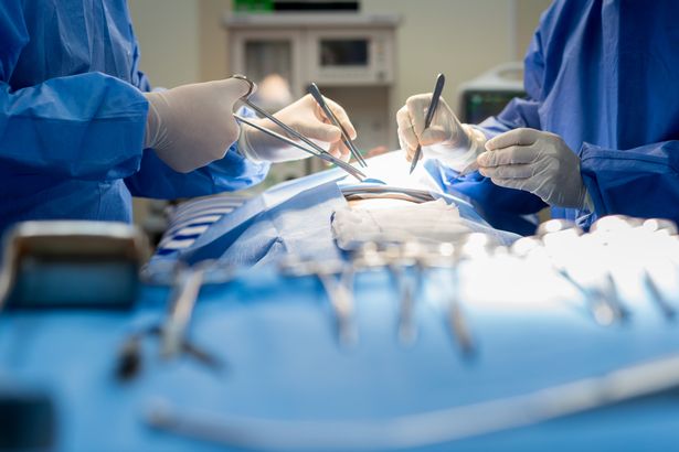 Doctor and an assistant in the operating room for surgical venous vascular surgery clinic in hospital - stock image