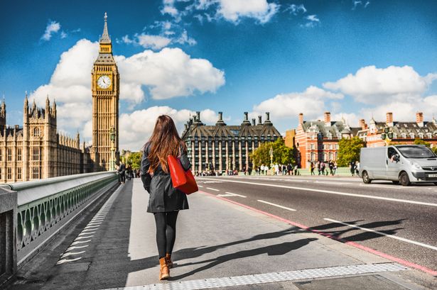 A woman walking through London with Big Ben in the background