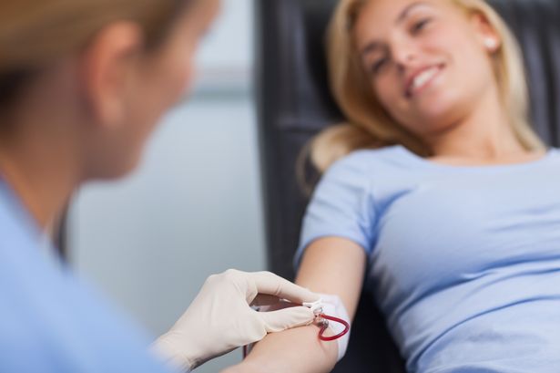 Nurse getting blood from on a female donor in a hospital