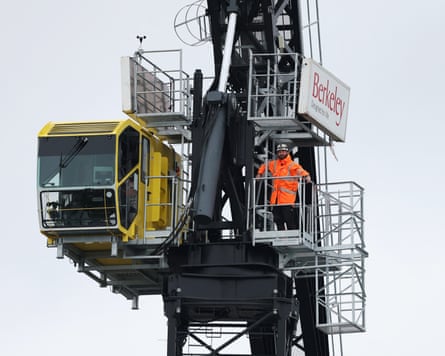 A construction worker watches the England v India Test from a crane by the Oval