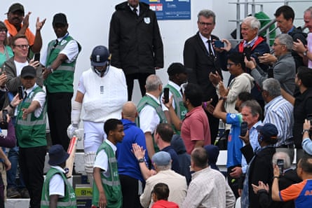 The crowd applaud and take photos as Chris Woakes walks out to bat with his left arm in a sling